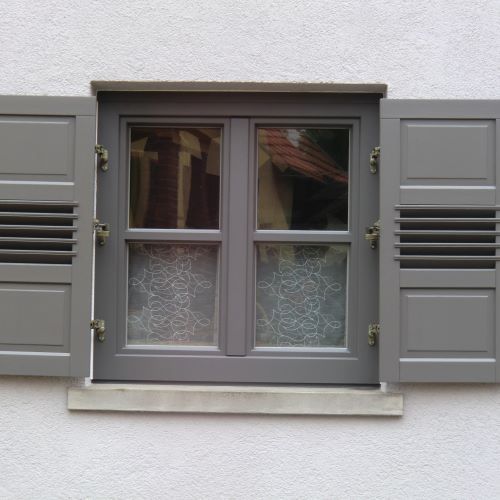 Sprossenfenster mit Klappladen in Grau verblendet